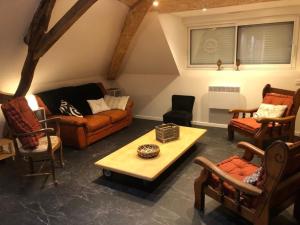 uma sala de estar com sofás e uma mesa de centro em Hameau des deux ailes em Précigné