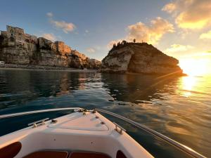 ein Boot im Wasser in der Nähe einer felsigen Insel in der Unterkunft B&B Costa degli Dei in Tropea