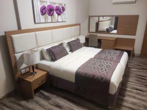 a bedroom with a large bed and a mirror at Altelal Tower Apartment in Makkah