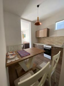 una cucina con tavolo e sedie in legno di Apartmani Vila a Cetinje (Cettigne)