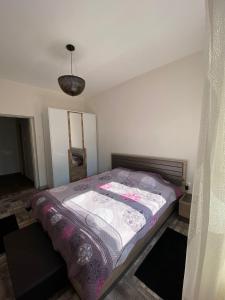 a small bedroom with a bed with a purple blanket at Apartmani Vila in Cetinje