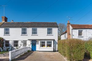 een wit huis met een blauwe deur bij Wheelwrights Cottage by Bloom Stays in Staple Cross
