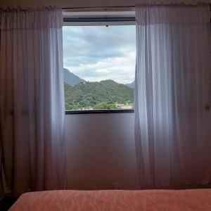 1 dormitorio con ventana y vistas a la montaña en Departamento Plaza 2 en Belén