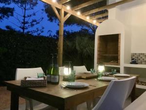 a wooden table with chairs and a bottle of wine at FONOLL MARÍ in Cala en Forcat