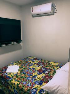 een slaapkamer met een bed met een bloemendeken en een kachel bij Casa No Centro Histórico in Logradouro