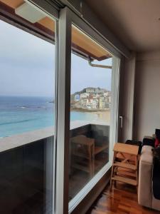 a room with a large window with a view of the ocean at Apartamento Sisargas in Malpica