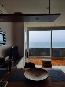 ein Wohnzimmer mit einem Tisch und einem großen Fenster in der Unterkunft Apartamento Sisargas in Malpica