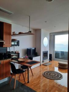 eine Küche mit einem Tisch und einem großen Fenster in der Unterkunft Apartamento Sisargas in Malpica