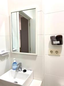 Un baño blanco con lavabo y espejo. en Apartamento Andalucia, en Tarifa