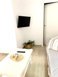 sala de estar con mesa blanca y TV en Apartamento Andalucia, en Tarifa