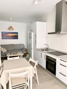 Una cocina y una sala de estar con mesa y sillas. en Apartamento Andalucia, en Tarifa