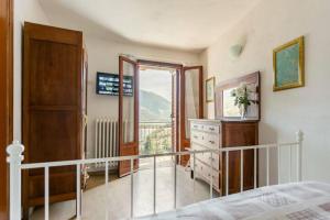 a bedroom with a bed and a dresser and a balcony at Casa con terrazzo vista Lago - LAKEHOLIDAY IT in Castel di Tora