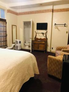 una camera d'albergo con letto e TV di The Palace Hotel a Silver City