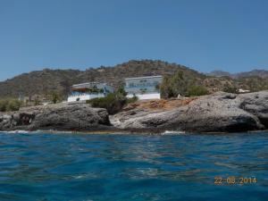 a house on top of some rocks in the water at Cypriana Apartments in Makry Gialos +27 photos