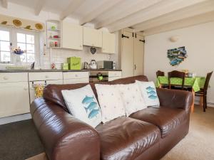a living room with a brown leather couch in a kitchen at Slate Cottage in Helland +8 photos
