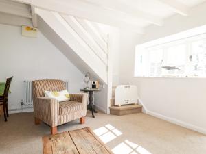 a living room with a chair and a window at Slate Cottage in Helland