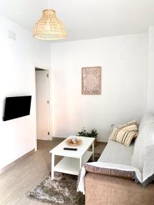 a white living room with a bed and a table at Apartamento Puerta Al Mar in Tarifa