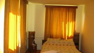 a bedroom with two beds and orange curtains at Lary Hostel in Suceava