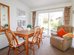 comedor con mesa, sillas y ventana en Harlyn en Mevagissey