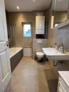 a bathroom with a sink and a toilet and a tub at Ferienwohnung Möwenblick in Wilhelmshaven