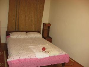 a bedroom with a pink bed with a red rose on it at Lary Hostel in Suceava