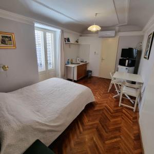 杜布羅夫尼克的住宿－Old Town Garden Room，卧室配有白色的床和书桌