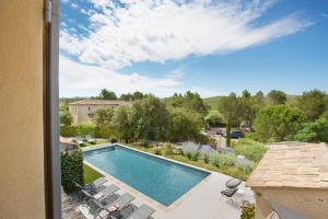 uma piscina com espreguiçadeiras ao lado de um quintal em Villa Briali Pont Royal em Mallemort