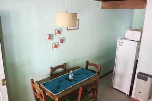 a kitchen with a table and a refrigerator at La Palapa ApartHotel in Villa General Belgrano