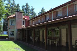 a building with a table and chairs in a yard at La Palapa ApartHotel in Villa General Belgrano