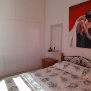 - une chambre avec un lit et une peinture murale dans l'établissement Esperides Sea, à Andros