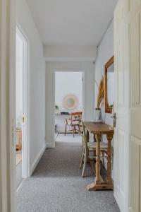 einen Flur mit einem Tisch und einem Stuhl in einem Zimmer in der Unterkunft The Malthouse - Naturally styled central apartment in Cirencester