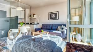 un soggiorno con divano blu e tavolo di Apartament 54 Holiday Mountain Residence - 5D Apartamenty a Świeradów-Zdrój