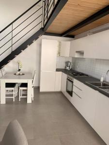 a kitchen with white cabinets and a table in it at Casa Rifa in Serramanna