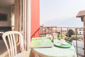 einen Tisch mit Tellern und Tassen auf einem Balkon in der Unterkunft Casetta Pina in San Siro