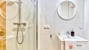 ein Badezimmer mit Dusche, Waschbecken und Spiegel in der Unterkunft Apartament 57 Holiday Mountain Residence - 5D Apartamenty in Świeradów-Zdrój