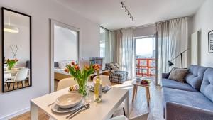 ein Wohnzimmer mit einem blauen Sofa und einem Tisch in der Unterkunft Apartament 57 Holiday Mountain Residence - 5D Apartamenty in Świeradów-Zdrój + 8 Fotos