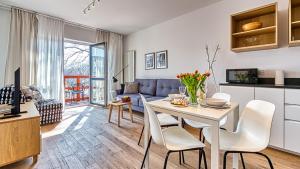 eine Küche und ein Wohnzimmer mit Tisch und Stühlen in der Unterkunft Apartament 57 Holiday Mountain Residence - 5D Apartamenty in Świeradów-Zdrój