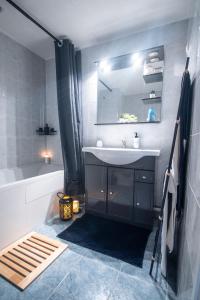 ein Badezimmer mit einem Waschbecken, einem Spiegel und einer Badewanne in der Unterkunft "LE PERSIAN" Studio à 3 min de la GARE, 10min du centre commercial, WIFI, PARKING in Courcouronnes