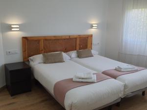 two beds in a bedroom with two towels on them at Autèntic Barcelona Monumental in Barcelona