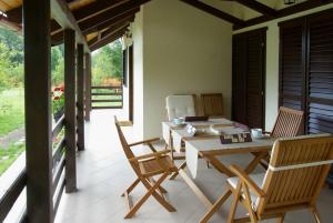 a patio with a table and chairs on a porch at Casuta cu prieteni in Cornu de Jos