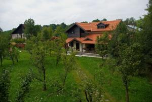 a house in the middle of a field with trees at Casuta cu prieteni in Cornu de Jos
