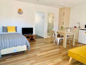 um quarto com uma cama, uma mesa e uma cozinha em Auckland Central Motel em Auckland