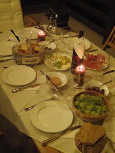 una mesa con platos de comida y copas de vino en Casuta cu prieteni, en Cornu de Jos