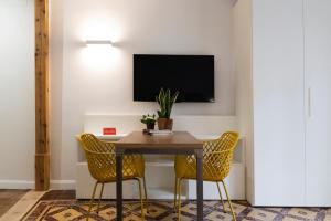 a dining room with a table and two yellow chairs at La Casa del Orfebre in Cuenca