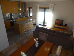 een keuken en een woonkamer met een bank en een tafel bij Pé No Mar Apartment in Vila do Conde