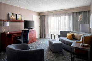 a hotel room with a couch and a tv at Sonesta Select Los Angeles Torrance South Bay in Torrance