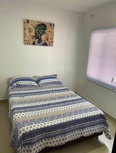Un dormitorio con una cama con una manta. en Aguamarina Inn - Casa de descanso con piscina - Tauramena Casanare en Tauramena