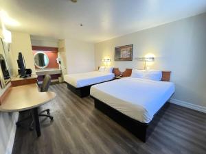 um quarto de hotel com duas camas e uma secretária em Motel 6 Barstow, CA I15 and Lenwood Road em Barstow