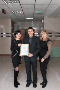 two women and a man holding a framed certificate at Hostel Omsk in Omsk