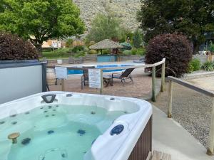 a jacuzzi tub in a yard with a picnic table at Similkameen Wild Resort & Winery Retreat in Cawston